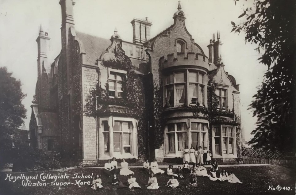 A group of children sitting in front of a buildingDescription automatically generated